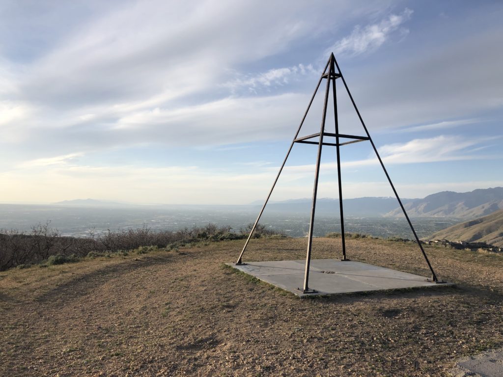 A pyramid shaped survey landmark structure in front of the mountain landscape